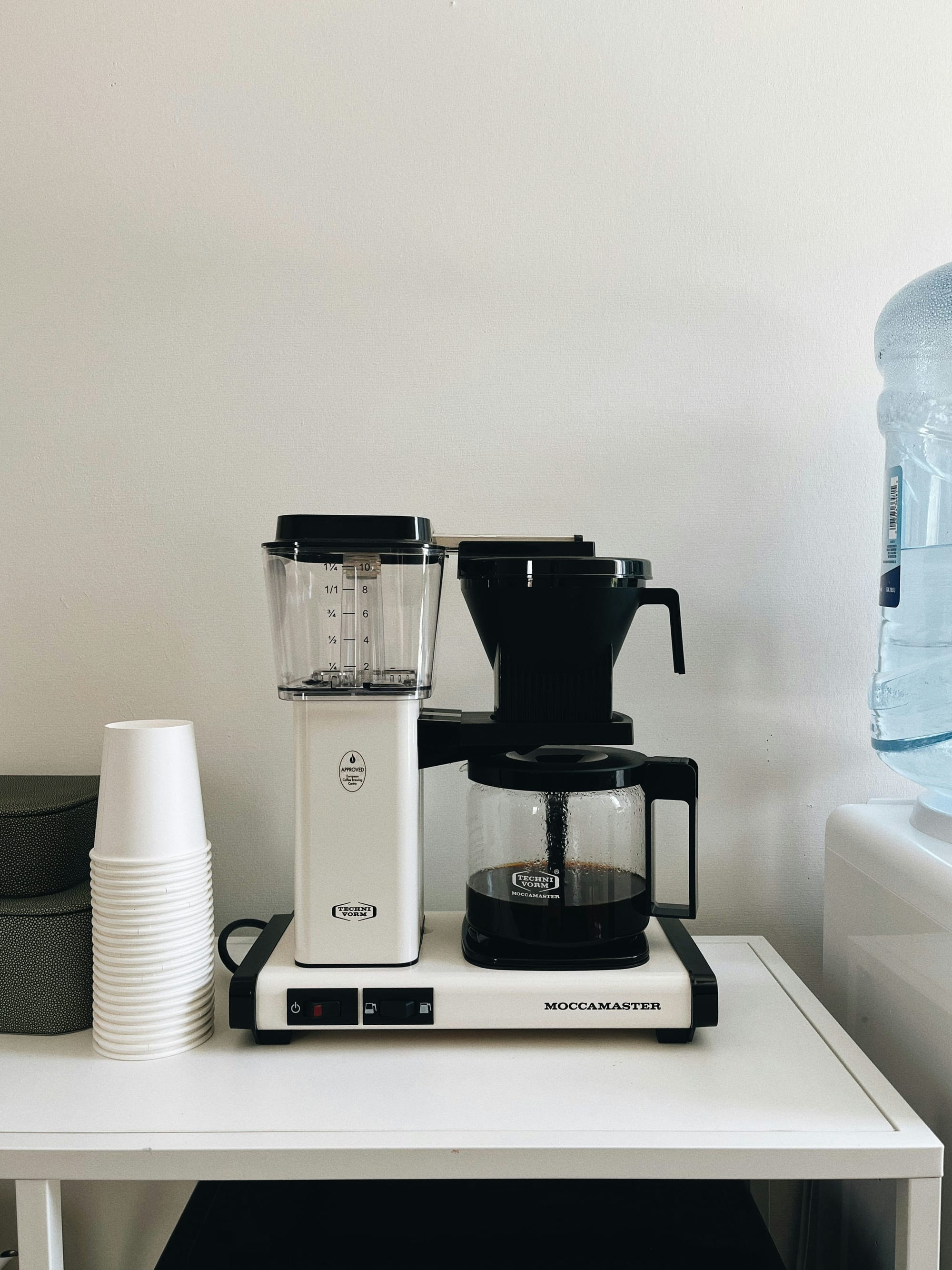 Freshly brewed cups of coffee being served in a modern office breakroom